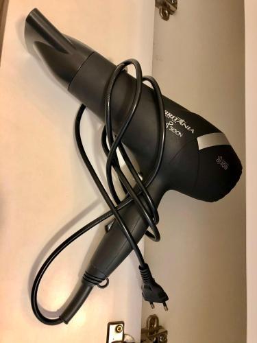 a black hair dryer hanging on a wall at Vista do Vale! 400 metros da Rua Coberta - Acomoda até 4 hóspedes in Gramado