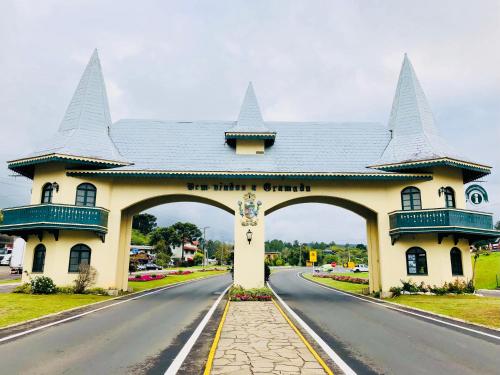 a building with an arch in the middle of a road at Vista do Vale! 400 metros da Rua Coberta - Acomoda até 4 hóspedes in Gramado