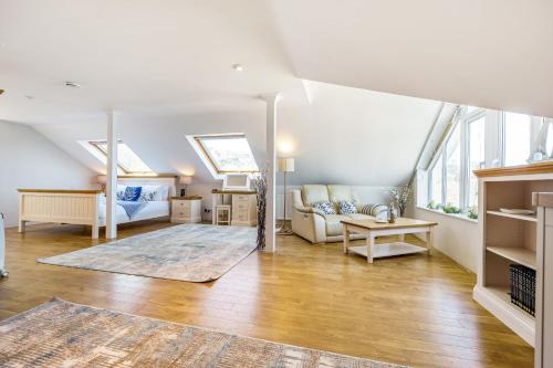 una gran sala de estar con paredes y ventanas blancas. en Carbis Bay - Luxury 3 Bed Penthouse Apartment with Sea Views Parking Sauna Balcony, en Carbis Bay