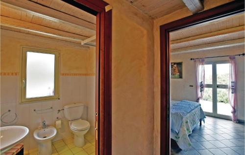 uma casa de banho com um lavatório, um WC e uma cama em Casa Montesole em Licata