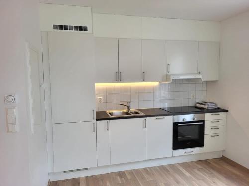 una cocina blanca con armarios blancos y fregadero en JECI Apartment Frogner, Lillestrøm - Classic and Central, en Lillestrøm
