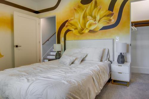 a bedroom with a large white bed with a flower on the wall at Modern Fairview Retreat Spacious Deck and Mtn View! in Fairview