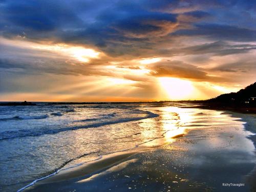 a sunset on a beach with the ocean at Hotel Ristorante Miramare in Pesaro