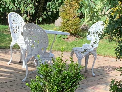two white chairs and a table in a garden at Windyridge in Aghagallon