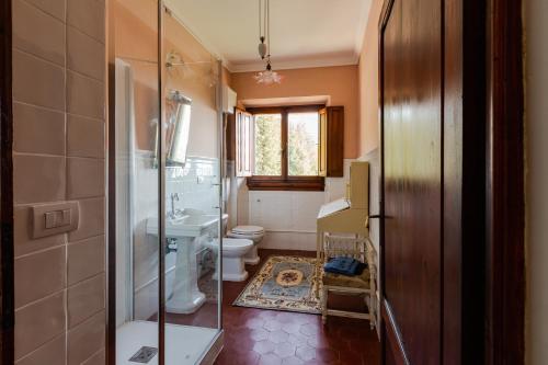 y baño con aseo, lavabo y ducha. en Villa Pasqui 1914 e Limonaia, en Città di Castello