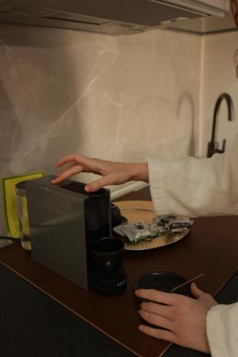 a person with their hand on top of a microwave at PALAZZO FIACCADORI - Historical Palace in Reggio Calabria