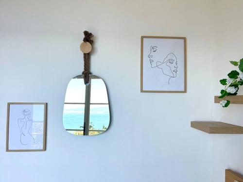 a light fixture hanging on a wall with pictures of women at Ô perché in Toulon