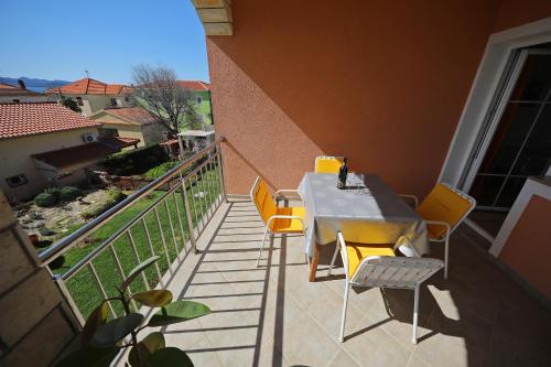 a table and chairs on the balcony of a building at Rooms & Studio apartmani Flower in Bibinje