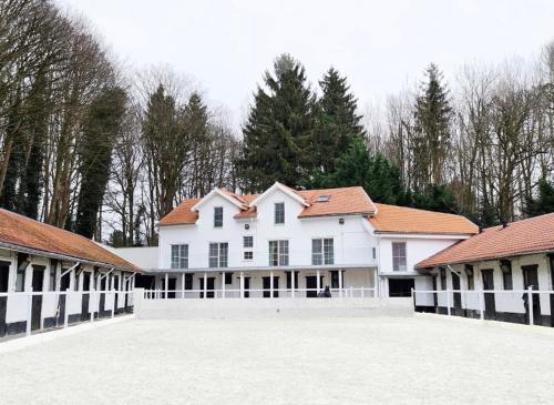 a large white house with red roofs at Royal Horses in Overijse