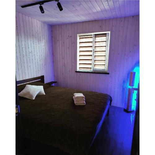 um quarto com uma cama num quarto roxo em Садиба Герасімових em Kamianets-Podilskyi