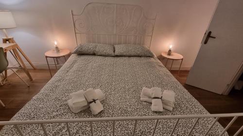 een bed met twee strikjes erop met twee tafels bij La Casa di G. in Rome