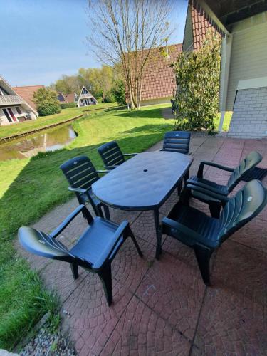 a picnic table and chairs on a brick patio at Vakantiehuisje in Gramsbergen in Gramsbergen