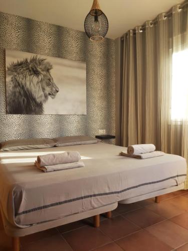 a bedroom with a bed with a picture of a lion at VILLA DEL MAR in Novo Sancti Petri