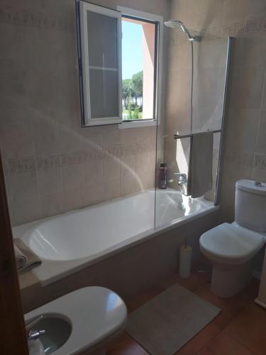 a bathroom with a tub and a toilet and a sink at VILLA DEL MAR in Novo Sancti Petri