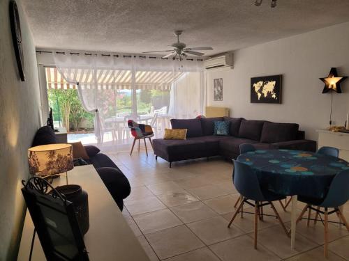 un salon avec un canapé et une table dans l'établissement Spacieux rez de jardin vue sur port de plaisance, au Grau-du-Roi