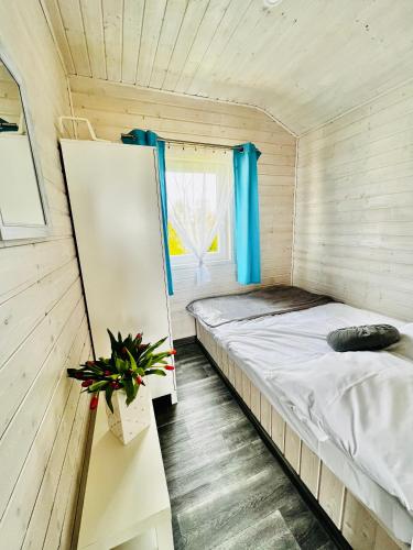 a bed in a small room with a window at Holiday Camp Sarbinowo in Sarbinowo