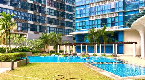 una piscina frente a un edificio en New & Modern Cozy 1BR w/ Balcony@BGC, WiFi 300MBPS, en Manila