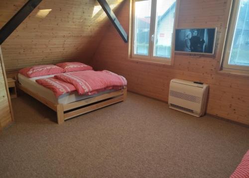 Un dormitorio con una cama con almohadas rojas. en Apartmánová chata Sečanda s bazénem, u Sečské přehrady, en Seč