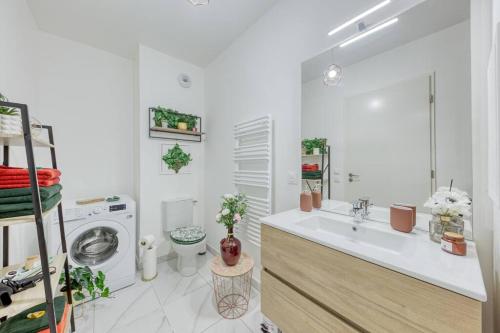 a bathroom with a sink and a washing machine at Easy Paris Visit Metro & Parking in Saint-Ouen