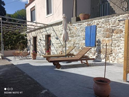 a patio with a chair and an umbrella at Stairs Homes & Suites in Kamária
