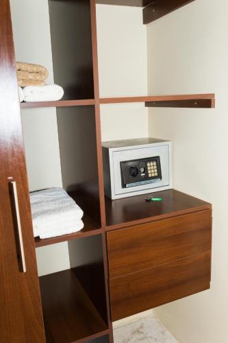 a book shelf with a microwave on top of it at El Suto Apart Hotel in San José de Chiquitos