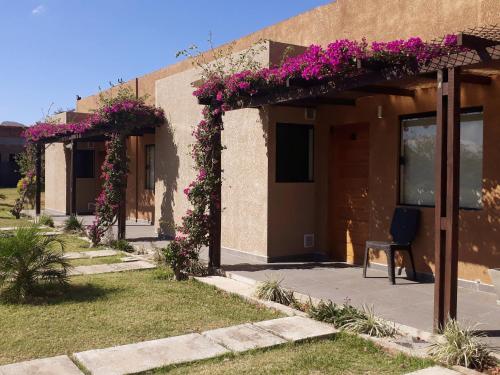 a building with purple flowers on the side of it at El Suto Apart Hotel in San José de Chiquitos