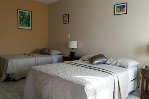 una camera con 2 letti e una lampada di El Suto Apart Hotel a San José de Chiquitos