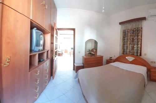 a bedroom with a bed and a tv on a cabinet at Sotirias hοuse in Symi
