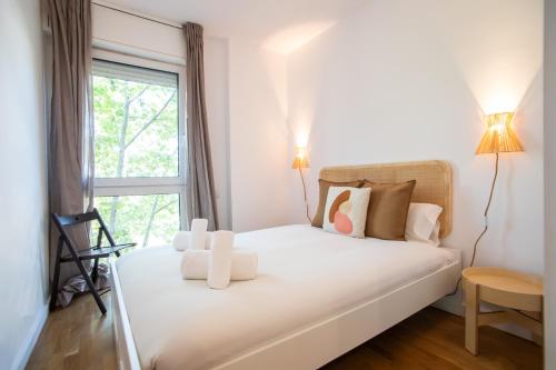 uma cama branca num quarto com uma janela em 31ARQ1044 - Maravilloso apartamento em Barcelona