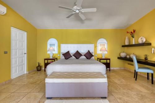 a bedroom with a bed and a ceiling fan at Villa La Vie en Bleu in Marigot
