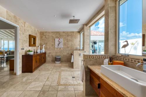 a large bathroom with a tub and a sink at Villa La Vie en Bleu in Marigot