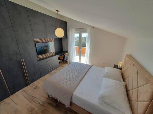 une chambre avec un grand lit blanc et une fenêtre dans l'établissement Apartman Rio de Mar, à Bibinje