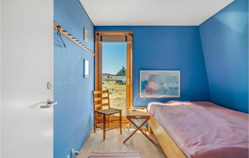 een slaapkamer met blauwe muren en een bed en een stoel bij Cozy Home In Vejby With Kitchen in Vejby