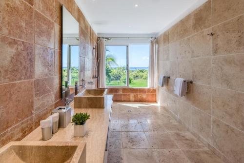 a bathroom with two sinks and a large window at Villa Lune de Miel in Marigot