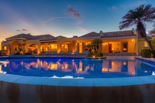 a large swimming pool in front of a house at Villa Terre Azure in Les Terres Basses