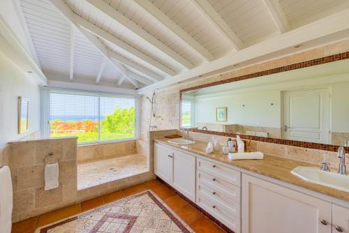 baño con 2 lavabos y ventana grande en Villa Lotus, en Marigot