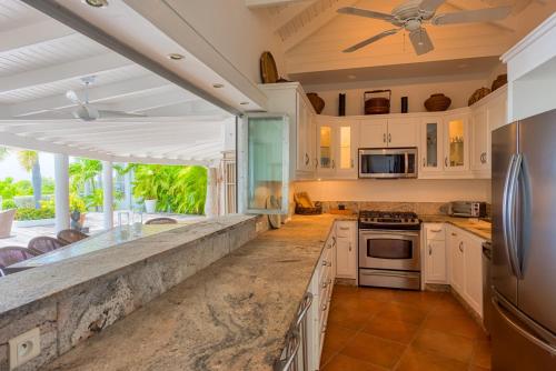 a kitchen with white cabinets and a ceiling at Villa Lotus in Marigot