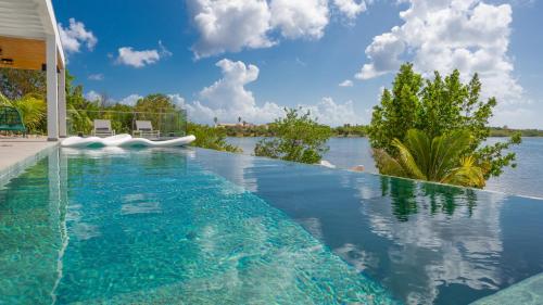 a swimming pool with a view of a body of water at Villa Enjoy in Les Terres Basses