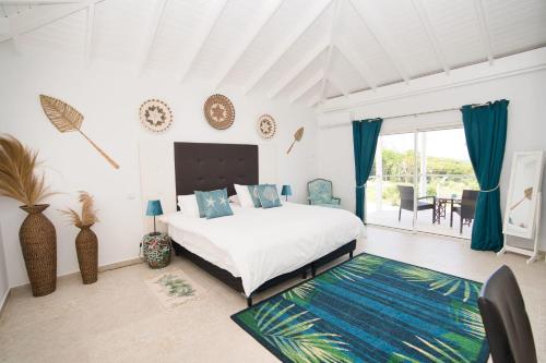 1 dormitorio con cama blanca y alfombra azul en Villa Infinity Blue, en Les Terres Basses