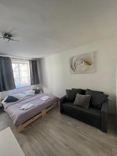 a bedroom with two beds and a couch at I&T Apartmán v srdci Broumova in Broumov