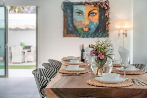 einen Esstisch mit einem Gemälde an der Wand in der Unterkunft Elegante y moderna Villa Miami in Adeje