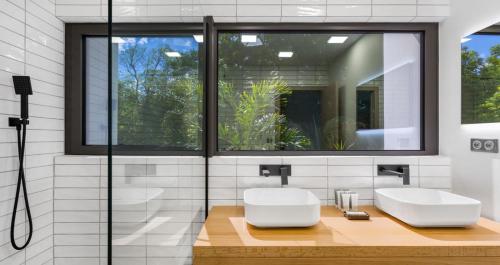 a bathroom with two sinks and a window at Villa Wellness in Baie Longue