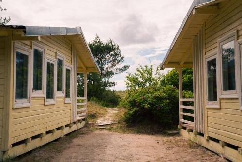 two wooden houses are next to each other at Energetikas • nameliai prie jūros in Šventoji