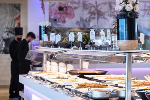 a buffet with plates of food on a table at ON Hotels Oceanfront Adults Designed in Matalascañas