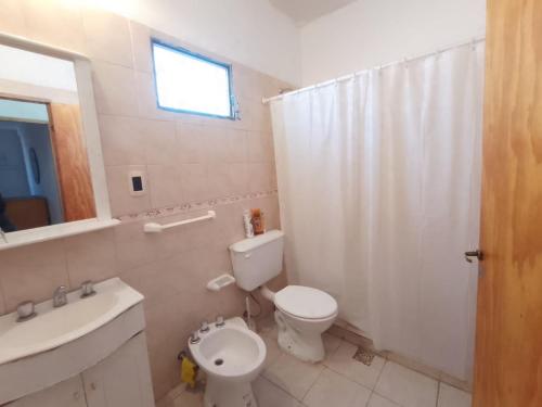 a white bathroom with a toilet and a sink at La Casa Amarilla CENTRO in San Rafael