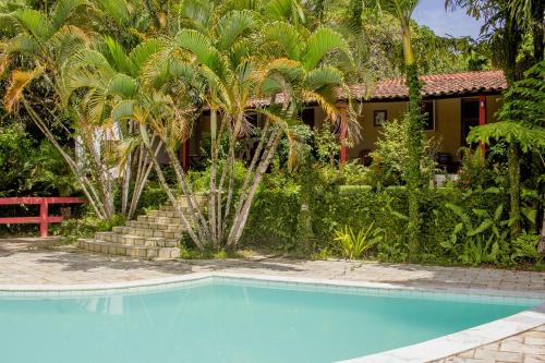 une piscine en face d'une maison avec des palmiers dans l'établissement Chacara c piscina e lazer Sao Lourenco da Mata PE, à São Lourenço da Mata