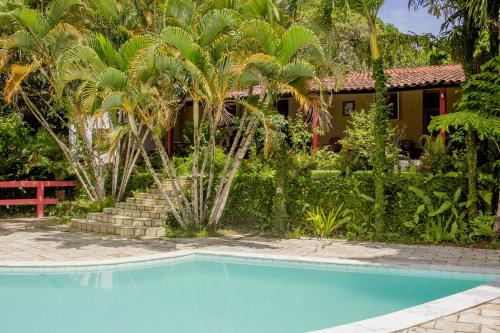 São Lourenço da Mata的住宿－Chacara c piscina e lazer Sao Lourenco da Mata PE，棕榈树屋前的游泳池