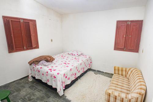 1 dormitorio pequeño con 1 cama y 1 silla en Chacara c piscina e lazer Sao Lourenco da Mata PE, en São Lourenço da Mata