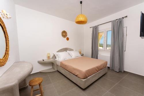 1 dormitorio con cama y ventana en Zaitun Luxury Suites en Karterados