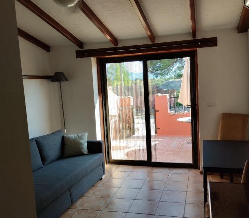 a living room with a couch and a sliding glass door at The Olive Mill in La Murada